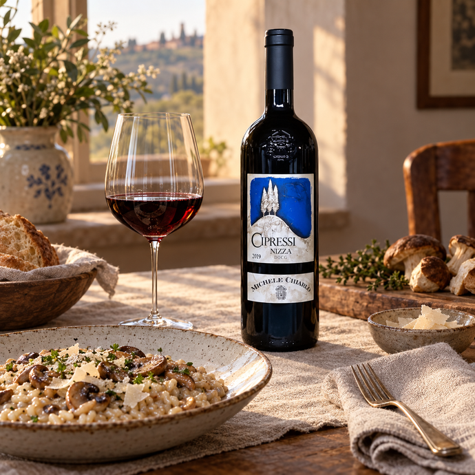 Botella de Michele Chiarlo Cipressi 2019 junto a una copa y un plato de pasta