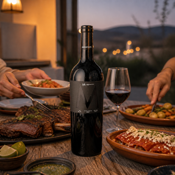Botella M de Mariatinto 2021 en una cena compartida con carne asada, enchiladas y vegetales al atardecer