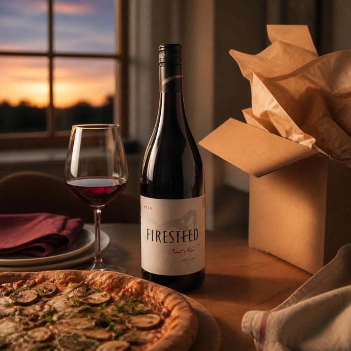 Firesteed Pinot Noir de la selección de agosto al abrir una caja del Club de Vinos Que Amamos en una mesa preparada para cenar
