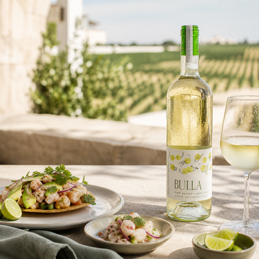 De Cote Bulla Blanco servido con ceviche y tostada de mariscos en una terraza de viñedo queretano
